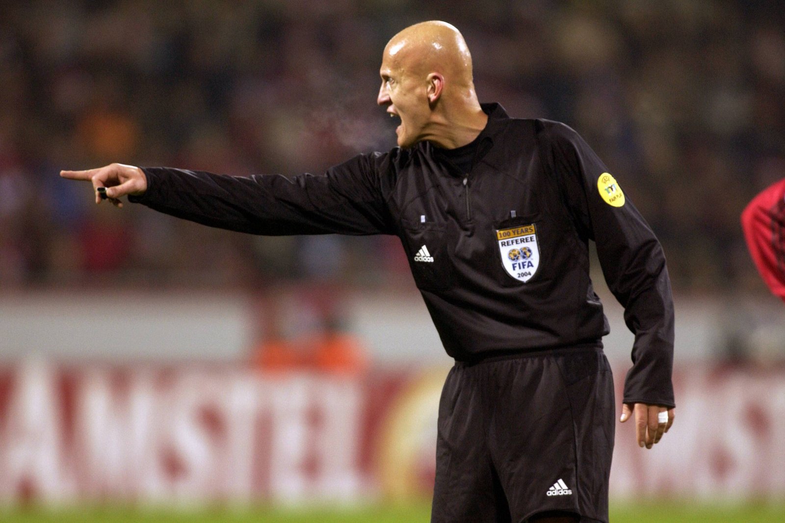 Pierluigi Collina sahada bir kararı işaret ediyor.
